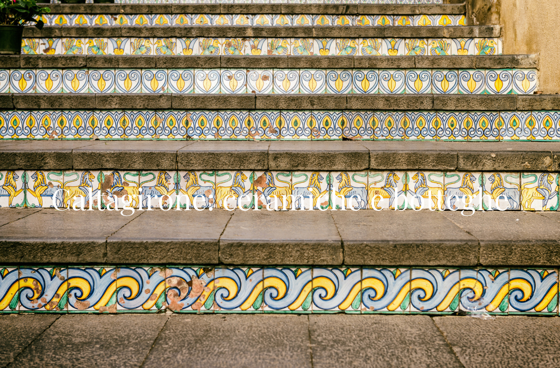 Alzate della scalinata decorate con maioliche, con il titolo Caltagirone: ceramiche e botteghe.