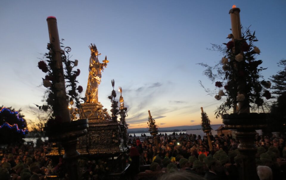 Il simulacro di Santa Lucia fra i ceri e la folla durante la processione a Siracusa.