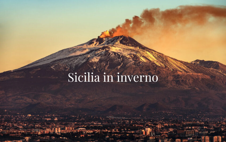 Etna con una colonna di fumo e città in basso, con il titolo Sicilia in inverno.