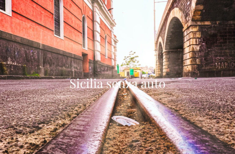 Binari fra edifici urbani, con il titolo Sicilia senza auto.