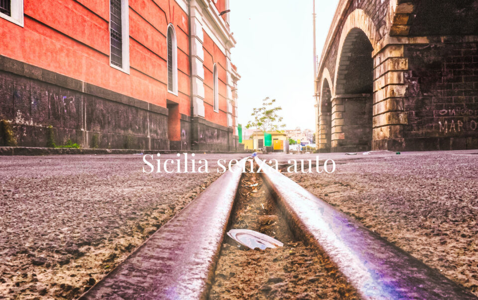 Binari fra edifici urbani, con il titolo Sicilia senza auto.