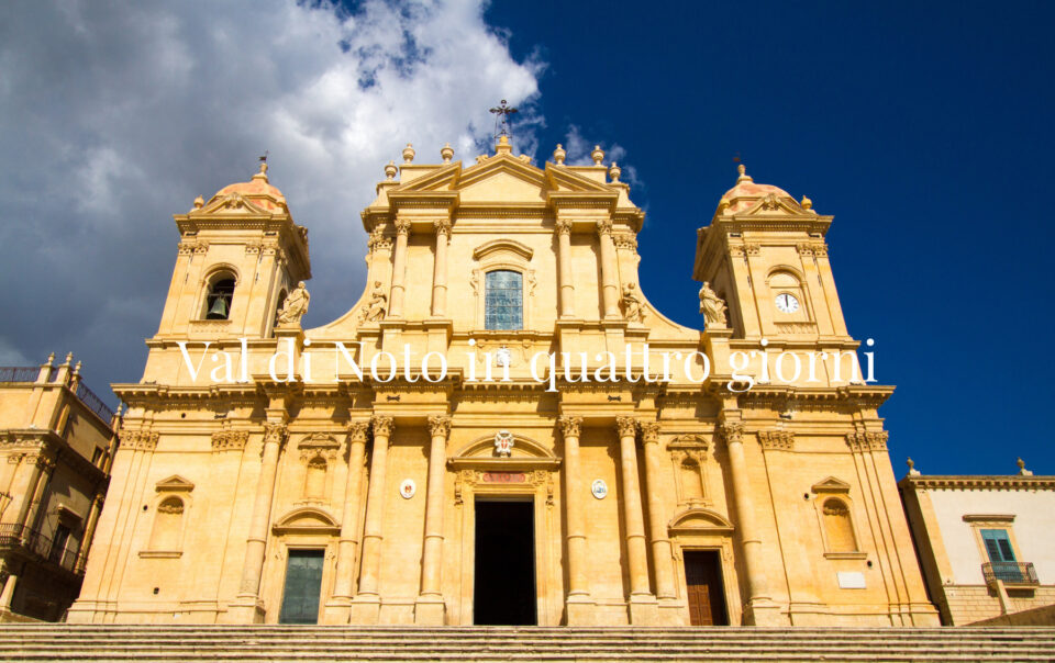 Facciata della Cattedrale di Noto sotto un cielo blu, con il titolo Val di Noto in quattro giorni.