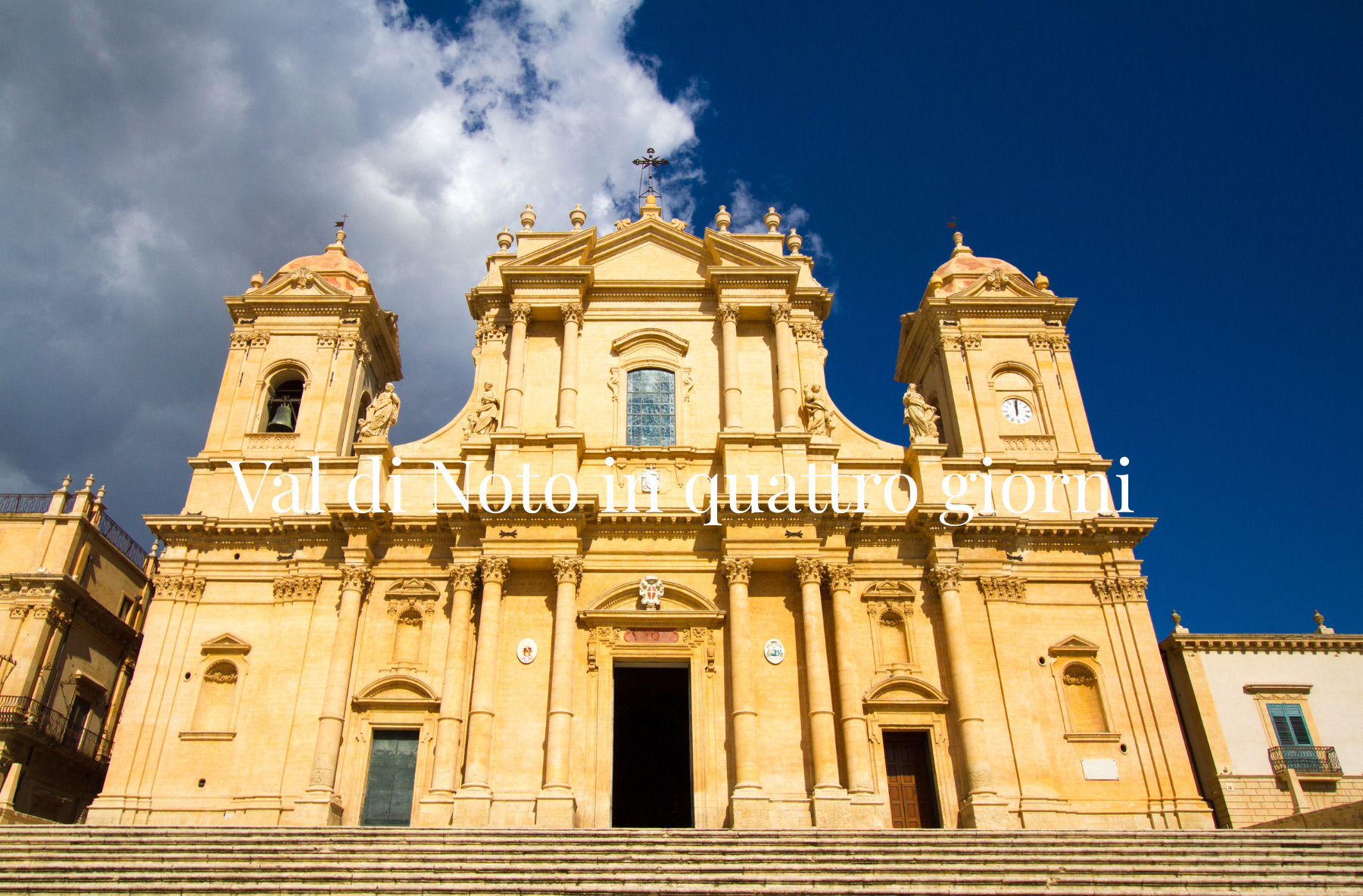 Facciata della Cattedrale di Noto sotto un cielo blu, con il titolo Val di Noto in quattro giorni.